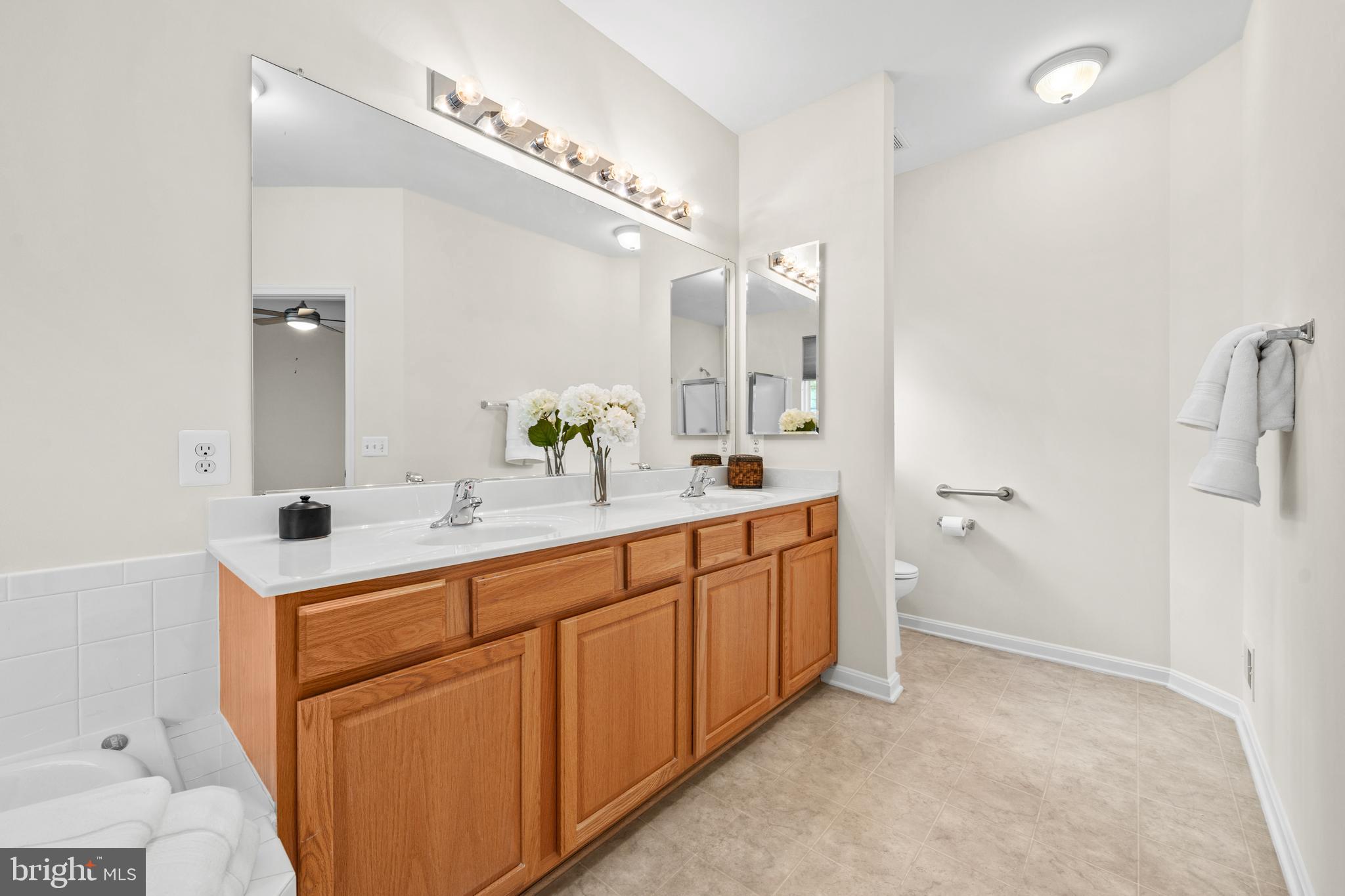 3948 Solstice Lane Dumfries, VA 22025 - Photo 13 of 27 a spacious bathroom with a double vanity sink and mirror