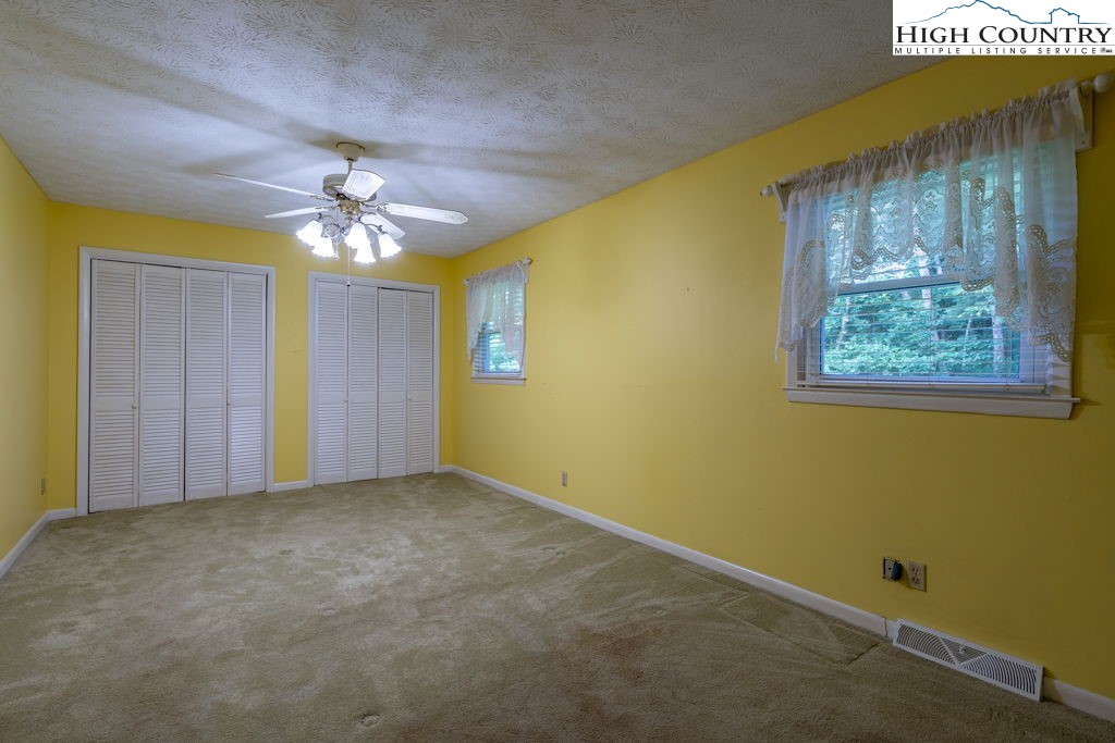 881 Queen Street Boone, NC 28607 - Photo 24 of 43 an empty room with a chandelier fan and a window
