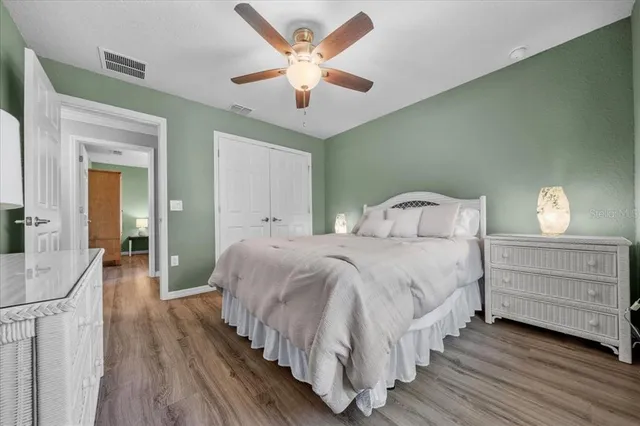a bedroom with a large bed chandelier and a window