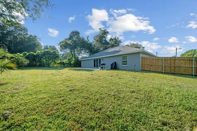 a front view of house with yard and trees in the background
