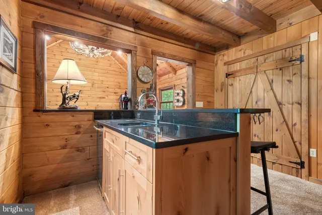a bathroom with a granite countertop sink and a large mirror next to a window