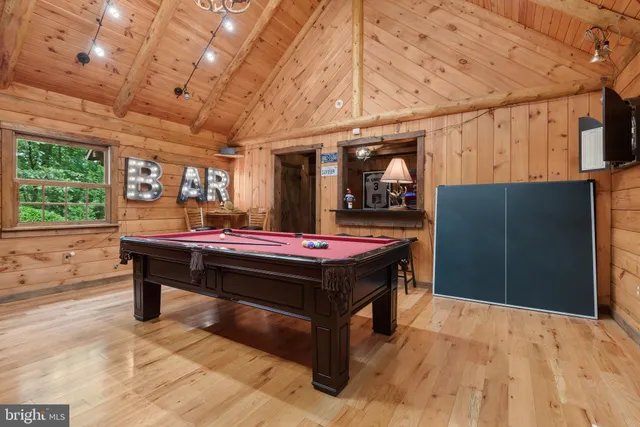a room with pool table and windows