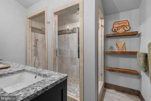 a bathroom with a granite countertop sink and a toilet