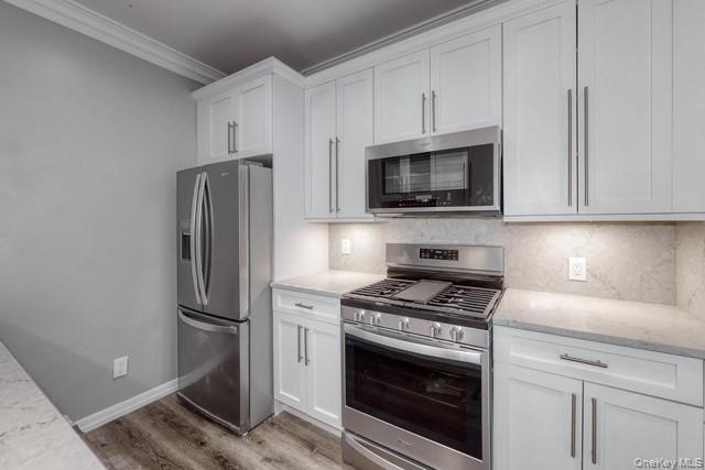 724 Howell Avenue, Unit E Riverhead, NY 11901 - Photo 2 of 10 a kitchen with cabinets stainless steel appliances and a counter space