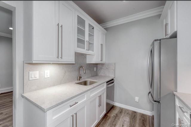 724 Howell Avenue, Unit E Riverhead, NY 11901 - Photo 3 of 10 a kitchen with stainless steel appliances granite countertop a refrigerator sink and white cabinets
