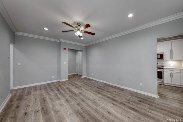 724 Howell Avenue, Unit E Riverhead, NY 11901 - Photo 5 of 10 a view of empty room with wooden floor and ceiling fan