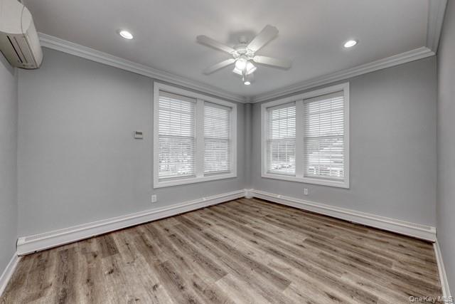 724 Howell Avenue, Unit E Riverhead, NY 11901 - Photo 6 of 10 a view of an empty room with a window and wooden floor