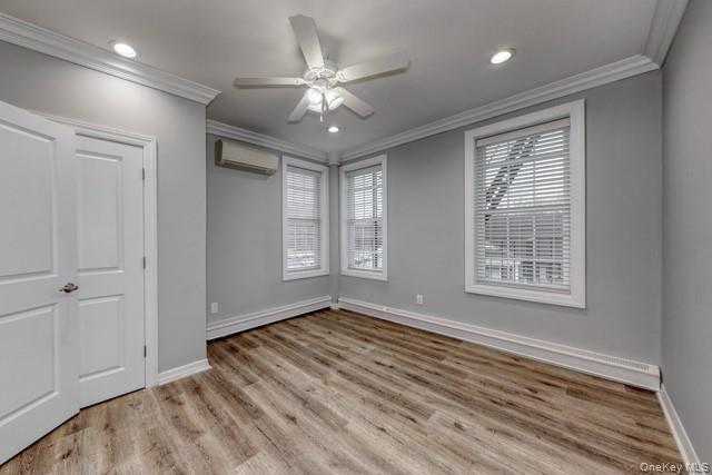 724 Howell Avenue, Unit E Riverhead, NY 11901 - Photo 8 of 10 a view of an empty room with a window and wooden floor