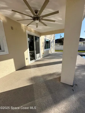 a view of a hallway with a large window and a chandelier