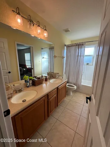 a bathroom with a sink vanity granite tub and a mirror