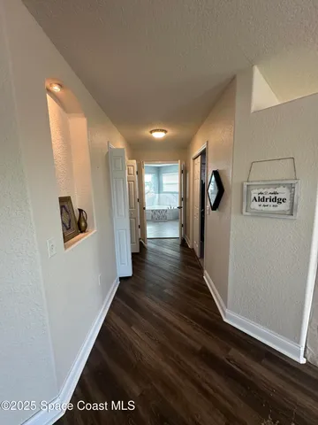 a view of a hallway with wooden floor
