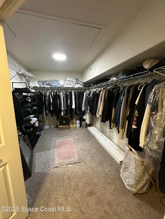 a view of walk in closet with lots of clothes