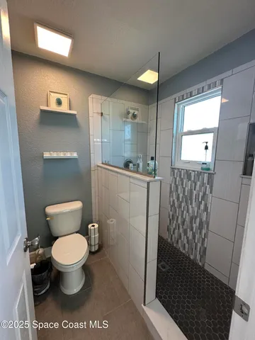 a bathroom with a toilet and a shower