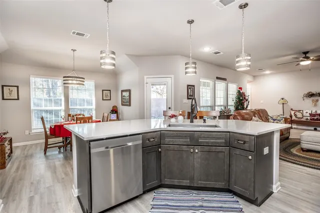 a kitchen with kitchen island granite countertop a sink a counter space dining table and chairs