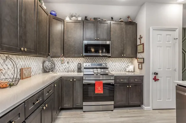 a kitchen with stainless steel appliances granite countertop a stove and a refrigerator