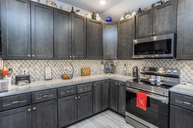 a kitchen with stainless steel appliances granite countertop a stove a sink and a microwave