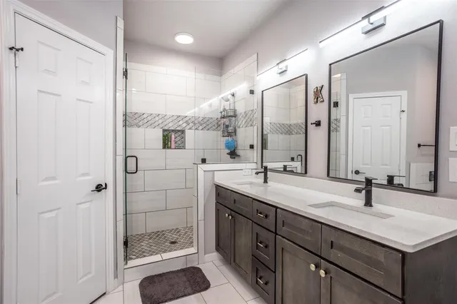 a bathroom with a shower sink and mirror