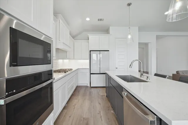 a large kitchen with stainless steel appliances kitchen island a large counter space a sink and cabinets