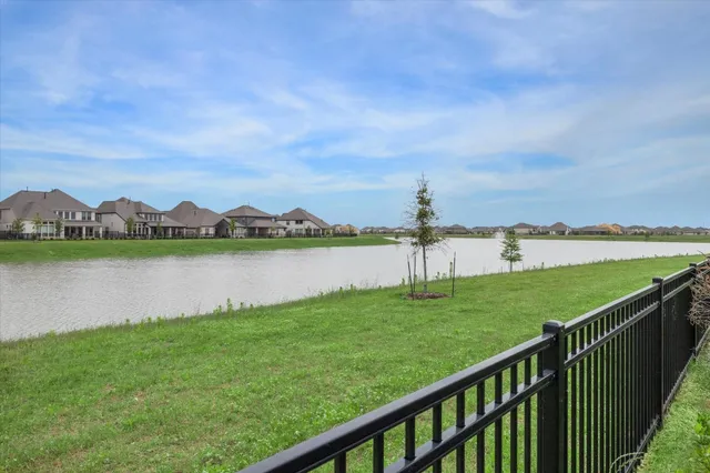 a view of green field with lake in front of it