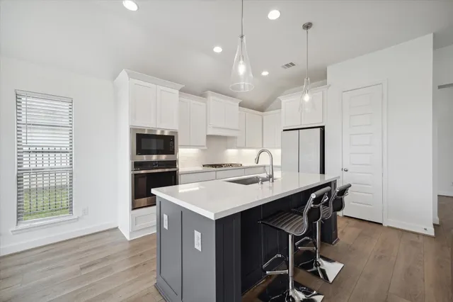 a kitchen with kitchen island a sink table and chairs