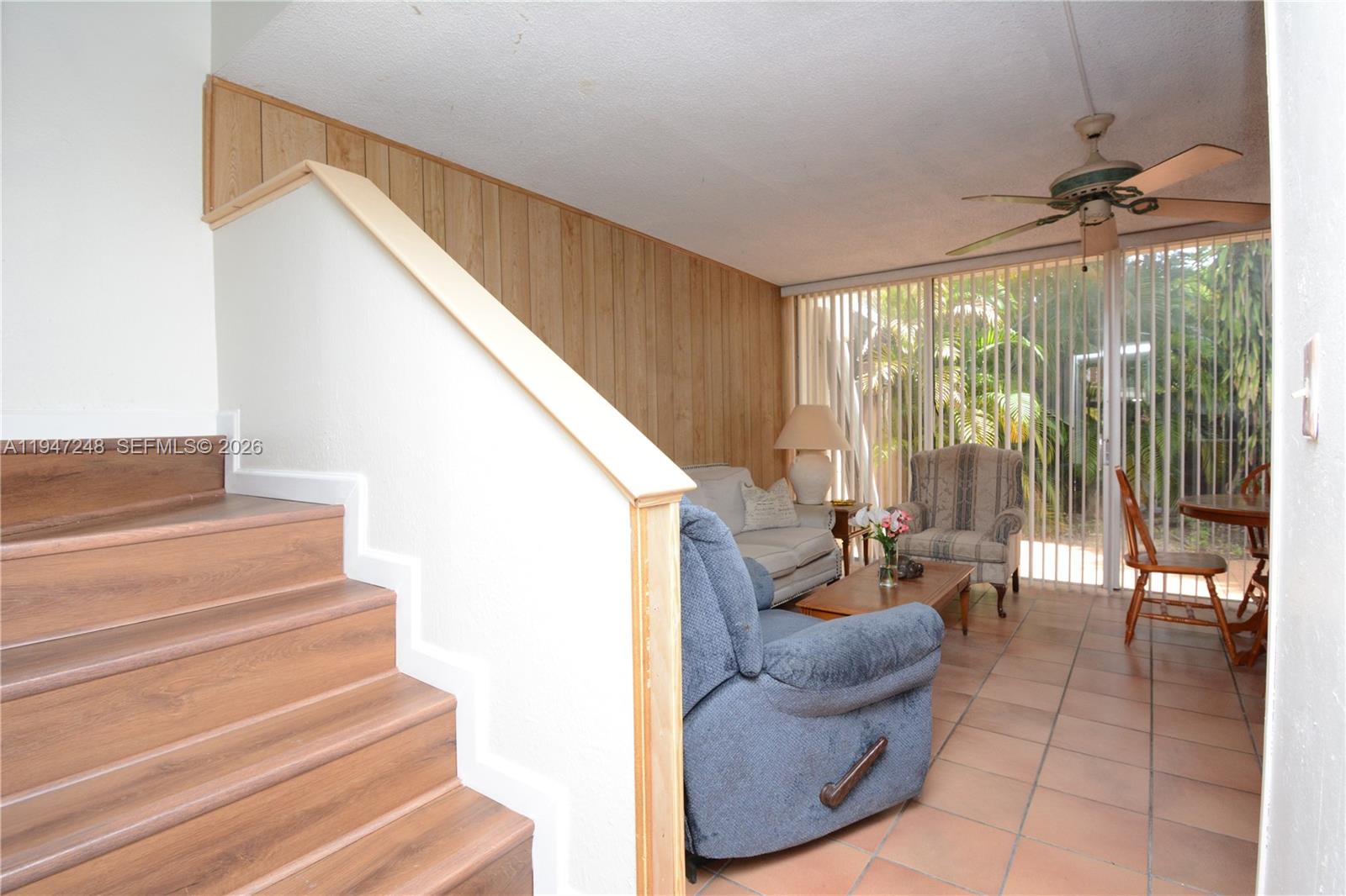 a living room with furniture and a floor to ceiling window