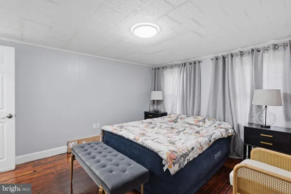 a bed sitting in a spacious bedroom next to a window