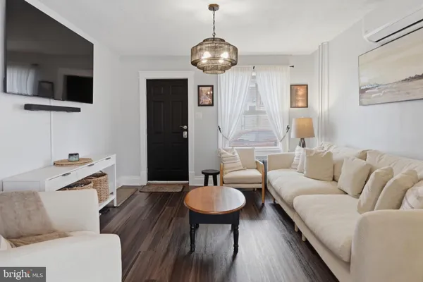 a living room with furniture a flat screen tv and kitchen view
