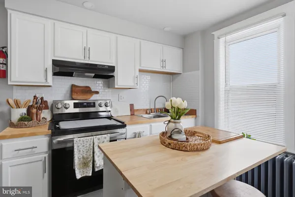 a kitchen with white cabinets and a stove