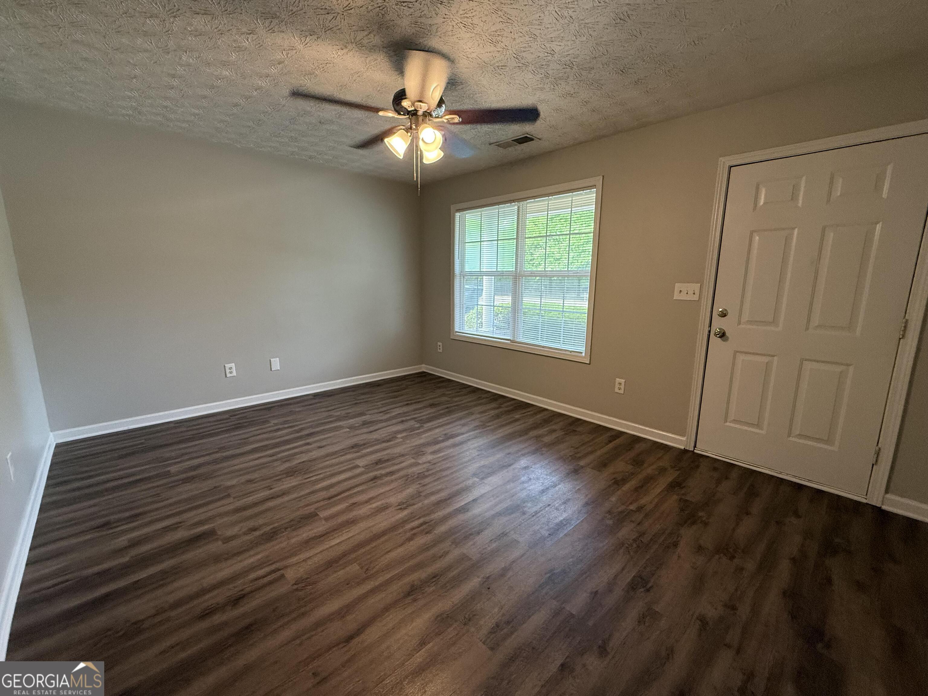 6132 Ruth Street Southwest Covington, GA 30014 - Photo 7 of 33 a view of an empty room with wooden floor and a window