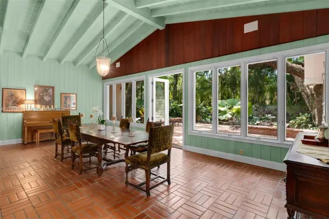 a dining room with furniture a large window and a rug