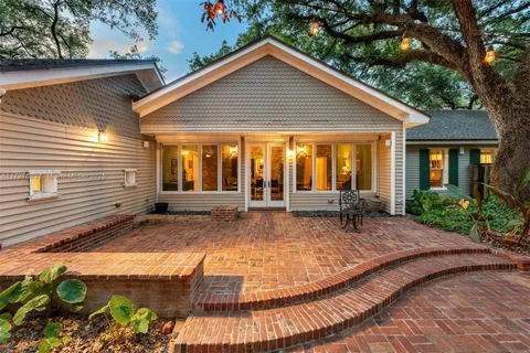 an aerial view of residential houses with outdoor space and trees