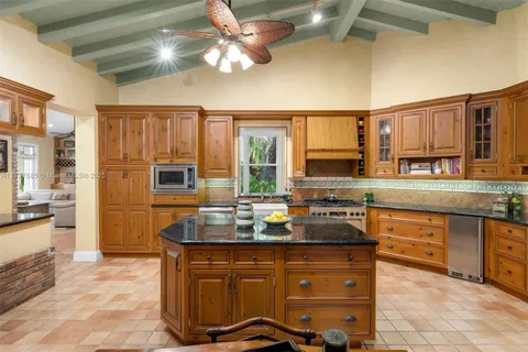 a dining room with furniture floor to ceiling windows and potted plants