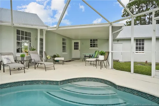 a view of a house with a big yard and large trees