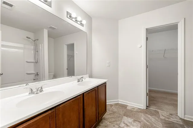 a bathroom with a double vanity sink a mirror and shower