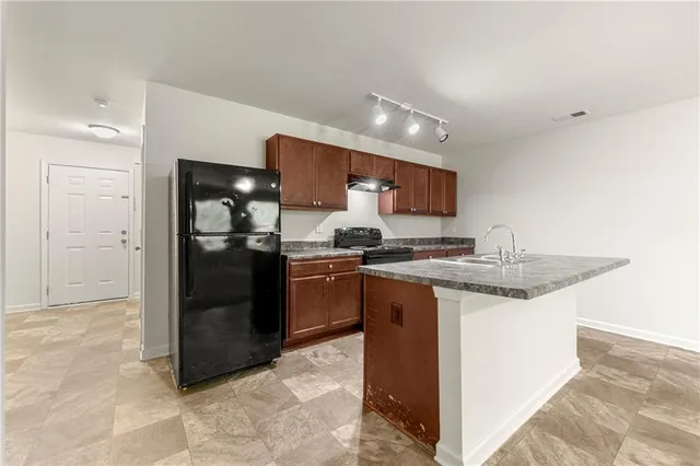 a kitchen with stainless steel appliances granite countertop a sink and a refrigerator