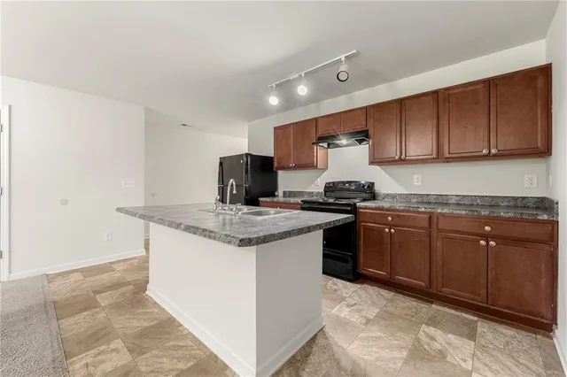 a kitchen with granite countertop a sink and a stove
