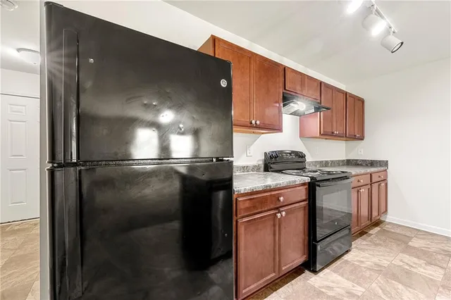 a kitchen with stainless steel appliances granite countertop a refrigerator a stove and a sink