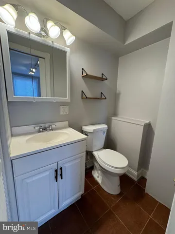 a bathroom with a granite countertop toilet sink and mirror