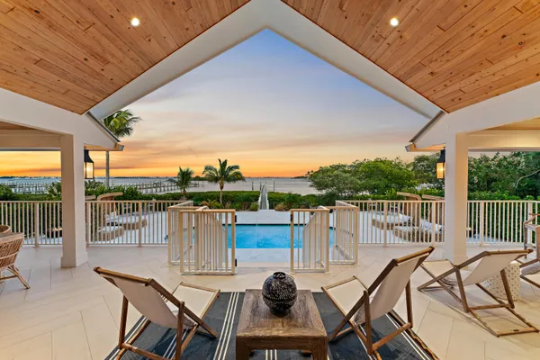 a view of a chairs and table in patio with a lake view