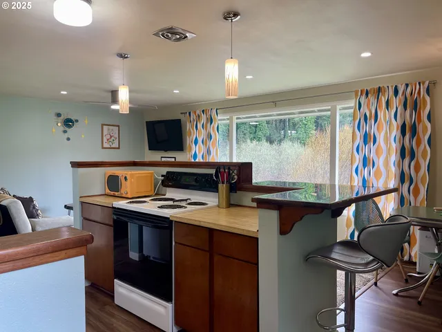 a kitchen with stainless steel appliances kitchen island granite countertop a refrigerator and a dining table