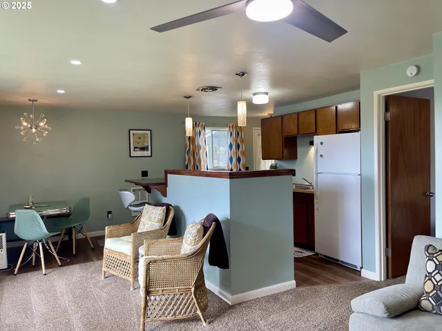 a view of a kitchen with fridge and wooden floor