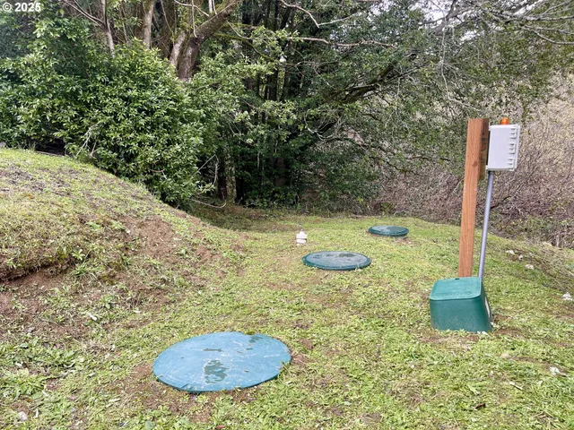 a view of a house with yard and trees in the background
