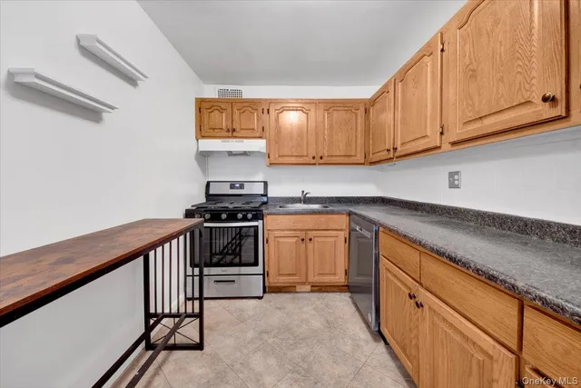 a kitchen with granite countertop white cabinets stainless steel appliances a sink and a counter space