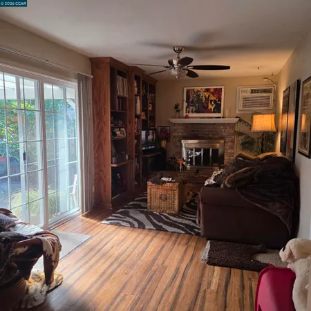 a living room with furniture a flat screen tv and floor to ceiling window