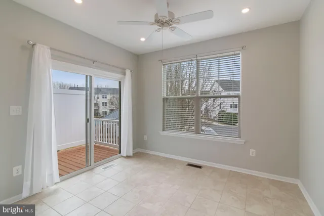 an empty room with a window and a ceiling fan