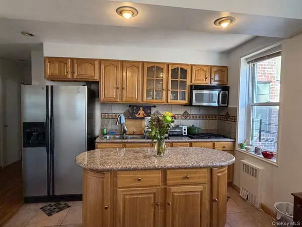 a kitchen with granite countertop kitchen island stainless steel appliances a refrigerator a stove a sink a dining table and chairs