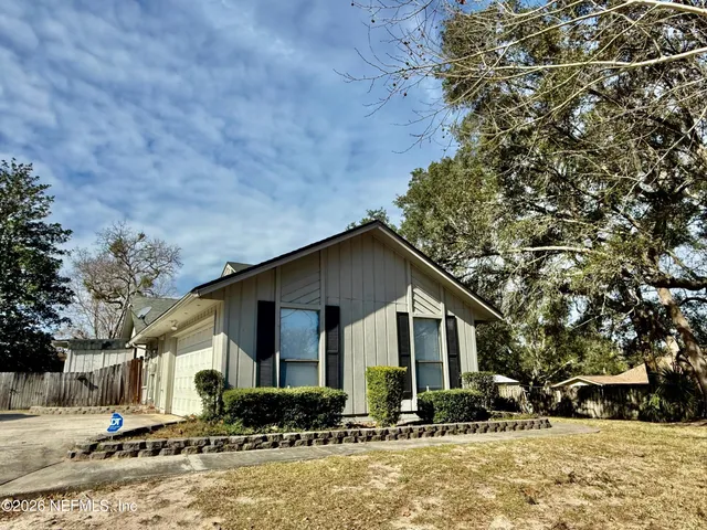 a front view of a house with a yard covered in snow