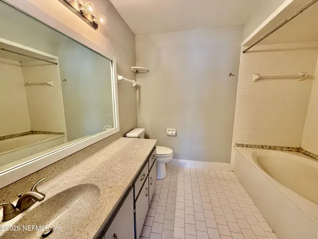 an empty room with a window and a ceiling fan