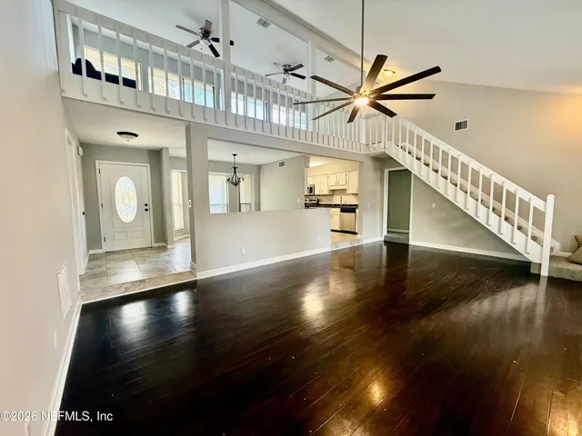 a view of a hallway with entryway wooden floor and a chandelier