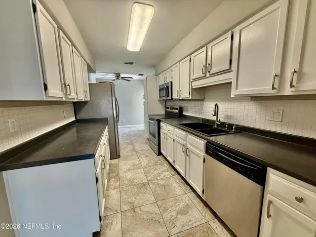 a kitchen with stainless steel appliances granite countertop a sink and a stove